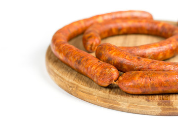 Raw homemade domestic sausage on the wooden board. Isolated over