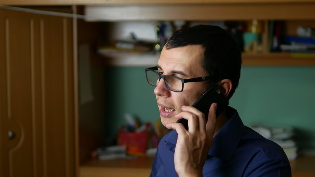 man with glasses talking on phone smartphone indoor