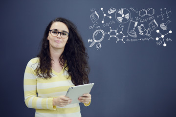 Woman with tablet in front of background with drawn business chart and icons.