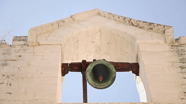 The belfry of a church. Reminiscent of spaghetti western movies. Close-up shot, warm colors.
