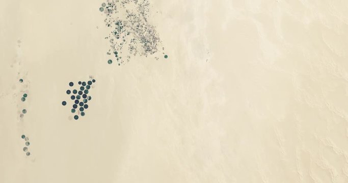 High-altitude overflight aerial of irrigated areas in the Murzuq sand sea, Libya. Clip loops and is reversible. Elements of this image furnished by USGS/NASA Landsat 


