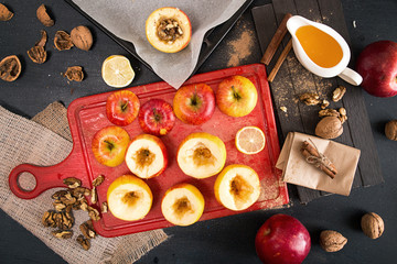Preparing baked apples stuffed with honey and walnuts on tray