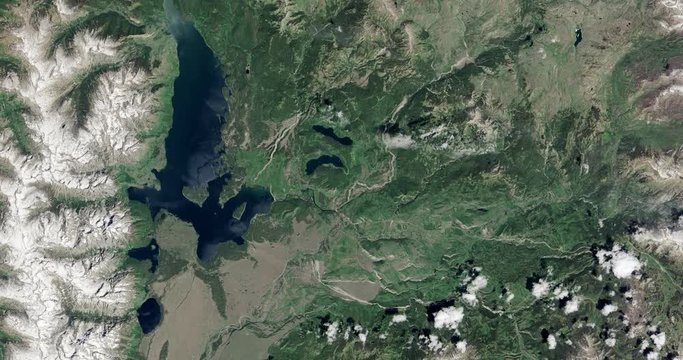 High-altitude overflight aerial of the Grand Tetons and surrounding land, Wyoming. Clip loops and is reversible. Elements of this image furnished by USGS/NASA Landsat 

