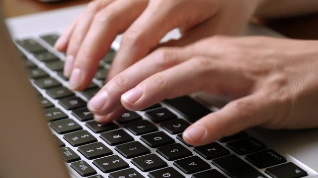 Female hands typing on a laptop keyboard
