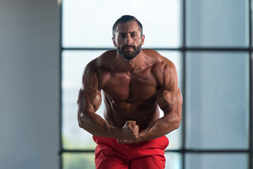 Plakat Muscular Man Flexing Muscles In Gym