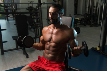 Biceps Exercise With Dumbbells In A Gym