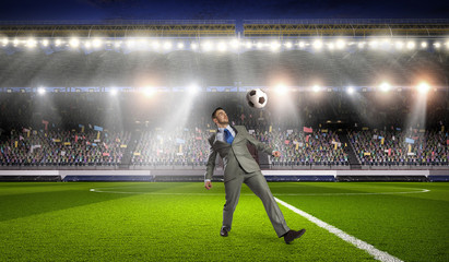 Businessman playing soccer . Mixed media