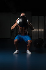 Fototapeta na wymiar Muscular Man Doing Medecine Ball Exercises