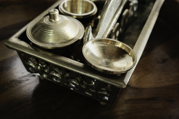 Malay heritage brassware, wedding equipment called Tepak Sireh over wooden background. shoot in low light and selective focus