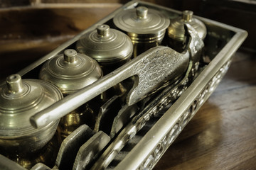 Malay heritage brassware, wedding equipment called Tepak Sireh over wooden background. shoot in low light and selective focus