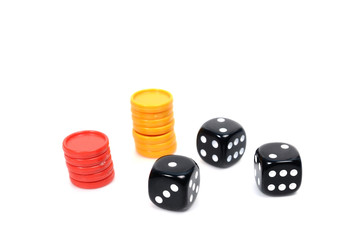 Three black dices and plastic coins for risk game.