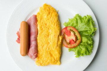 Breakfast of omelette with tomatoes and vegetable on dish.