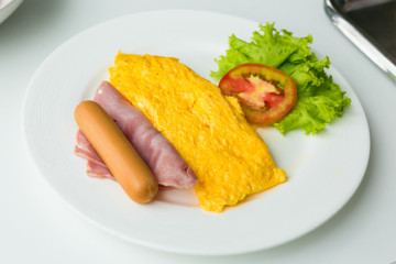 Breakfast of omelette with tomatoes and vegetable on dish.