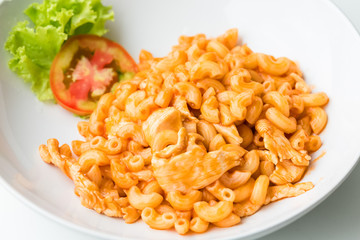 Macaroni and tomato sauce with chicken meat decorated with scall
