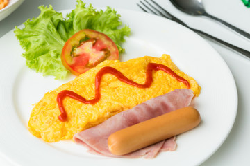 Breakfast of omelette with tomatoes and vegetable on dish.