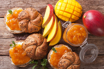Buns with mango marmalade, butter and decorated with mint close up. horizontal top view