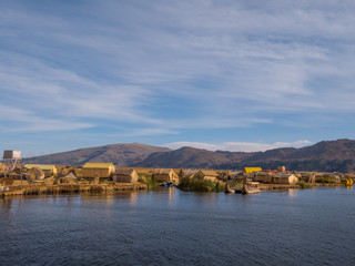 View of the Uros floating reed islands with boats, mysterious Lake Titicaca, Puno Region, Peru