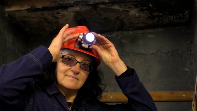 Woman is testing miner's helmet LED light