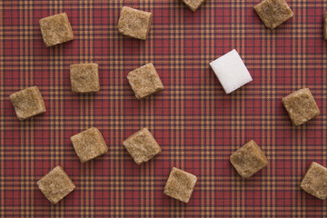 Brown and white sugar cubes on red background. Copy space. Top view