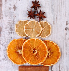 Fototapeta na wymiar Christmas tree shape made of dried orange, lemon and anise on old wooden background