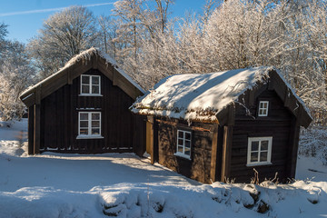 Old wooden cottages in winter landscape