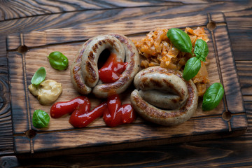 Serving board with bbq coiled sausages and braised cabbage