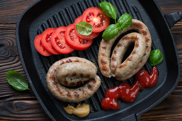 Cast-iron pan with barbecued coiled sausages, view from above