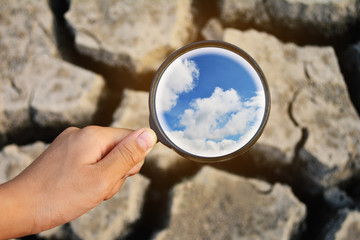 Hand  holding magnifier and find nature on  dry ground