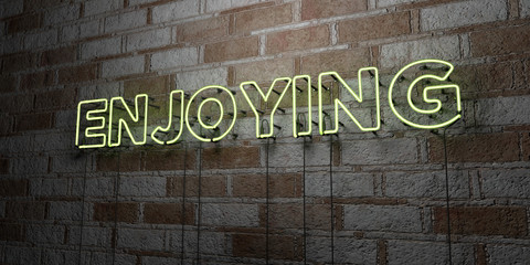 ENJOYING - Glowing Neon Sign on stonework wall - 3D rendered royalty free stock illustration.  Can be used for online banner ads and direct mailers..