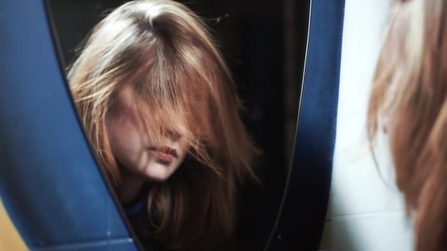 tired drunk woman in front of a mirror