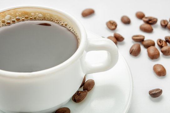 Close-up hot coffee with beans on light background