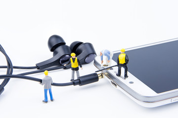 Miniature tiny toys team of engineers are doing connected cable