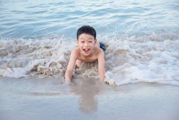 Young asian boy playing on the beach