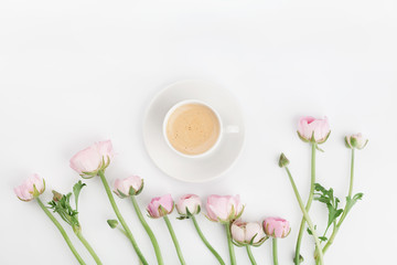 Obraz na płótnie Canvas Beautiful spring Ranunculus flowers and cup of coffee on white table from above. Greeting card. Breakfast. Pastel color. Clean space for text. Flat lay style.