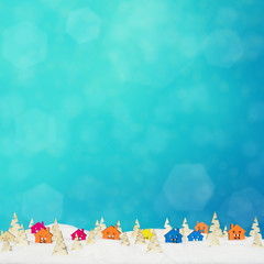 Christmas background with small wooden houses, Christmas trees and snow