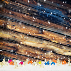 Christmas background with small wooden houses, Christmas trees and snow