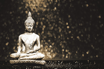Buddha statue on a bright shiny background with bokeh. Photo in vintage style