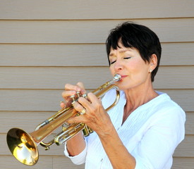 Female trumpet player blowing her horn.