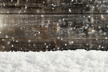 Christmas background with snow and blurred wood texture