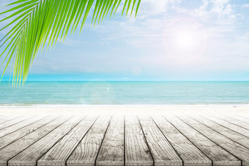 Fototapeta premium old wood table top on blurred beach background with coconut leaf. Concept Summer, Beach, Sea, Relax.