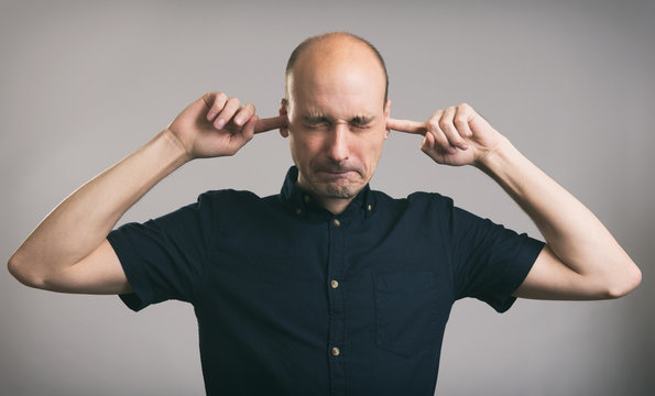 Man covering his ears