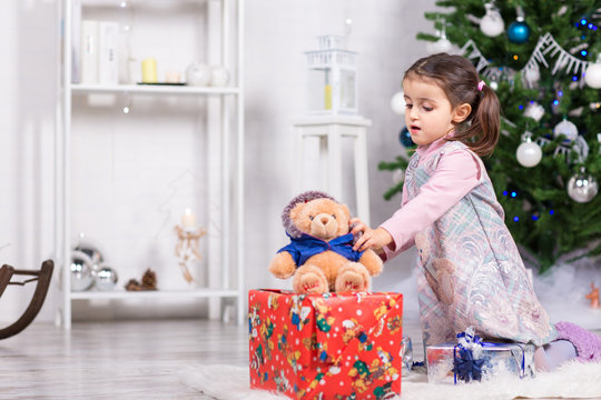 Bambina con peluche e regali di Natale