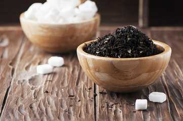 Raw tea and white sugar on the wooden table