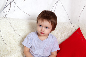 Adorable little boy in a New Year red white interior