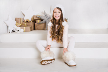 Portrait of little fashion kid girl on the background of a Christmas decor

