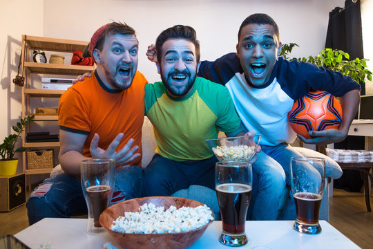 Picture of happy friends watching football game and screaming when someone kicked goal. Football concept.