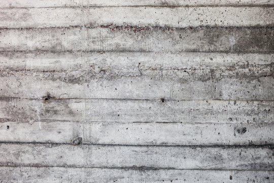 Grey concrete wall with hardened traces of the shuttering moulds