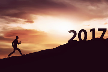 Silhouette man running on the hill toward 2017