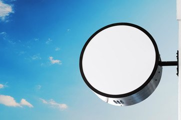Blank circle signboard, wall installation, on blue sky