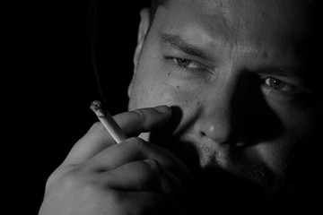Obraz premium Young man smoking cigarette monochrome